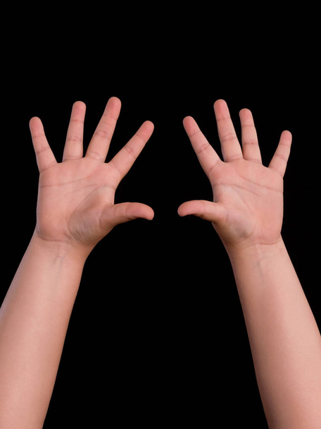 χέρια ψηλά από αγόρι απομονωμένο σε μαύρο φόντο - Φωτογραφία, εικόνα