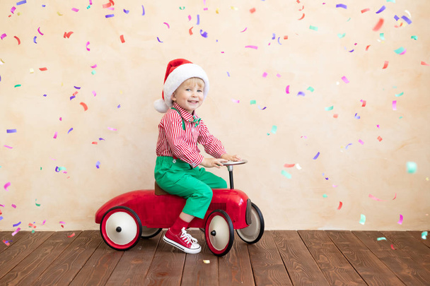 Happy child wearing Santa Claus costume playing at home - Fotografie, Obrázek