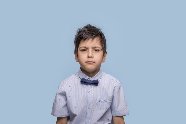 Halblanges Potrait eines wütenden Jungen in blauem Hemd mit Bo - Foto, Bild