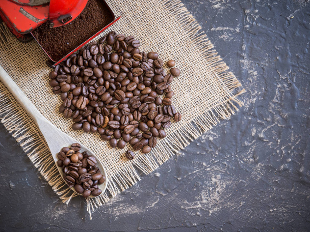 scéna o kávě v horní pohled. Ročník červená mlýnek na kávu, dřevěná lžíce a kávová zrna - Fotografie, Obrázek