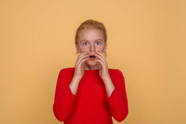 Érzelmi portré egy fiatal rémült lányról vörös hajjal és frec-kel - Fotó, kép