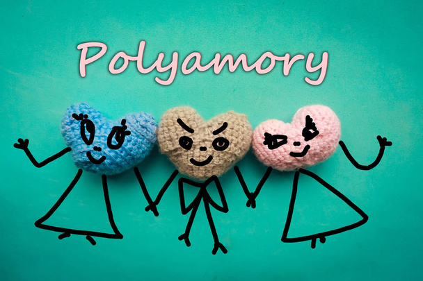 Three knitted hearts on blue background and the text - polyamory - Photo, Image