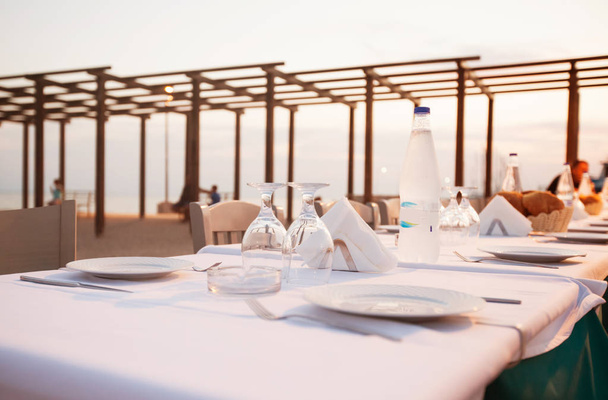 Ajuste de mesa del restaurante para la cena en la playa
 - Foto, Imagen