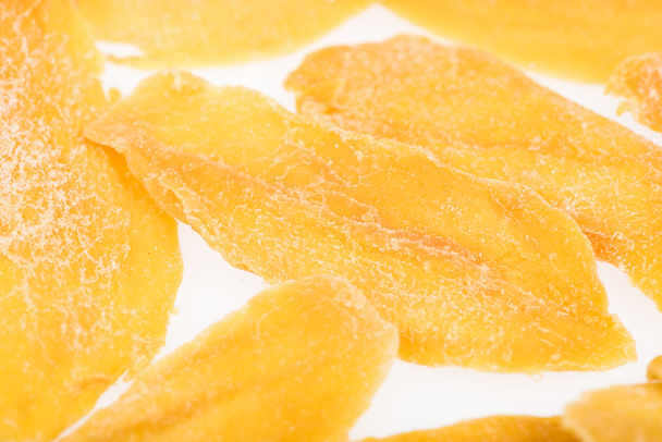 close-up zicht op gedroogde mango plakjes geïsoleerd op wit - Foto, afbeelding