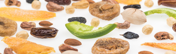 close-up uitzicht op smakelijke geassorteerde noten, gedroogde vruchten en gekonfijte vruchten geïsoleerd op wit, panoramisch schot - Foto, afbeelding