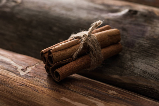 close up view of cinnamon sticks on wooden background - Фото, изображение