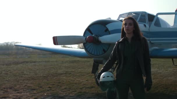 κορίτσι πιλότος κοντά στο αεροπλάνο - Πλάνα, βίντεο