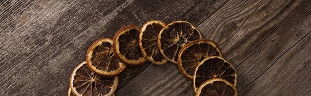 vista superior de fatias de laranja secas no fundo de madeira, tiro panorâmico
 - Foto, Imagem