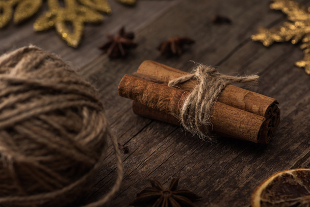 selective focus of ball of thread and cinnamon sticks on wooden surface - 写真・画像