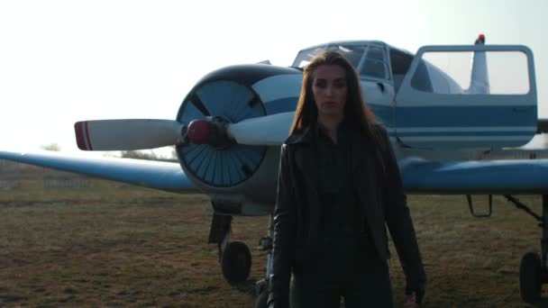 κορίτσι πιλότος κοντά στο αεροπλάνο - Πλάνα, βίντεο