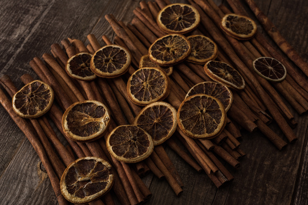 dried orange slices and cinnamon on wooden background - Photo, Image