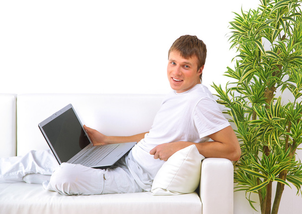 student ontspannen met zijn laptop op een bank - Foto, afbeelding