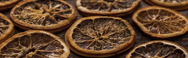 panoramic shot of dried orange slices on wooden background - 写真・画像