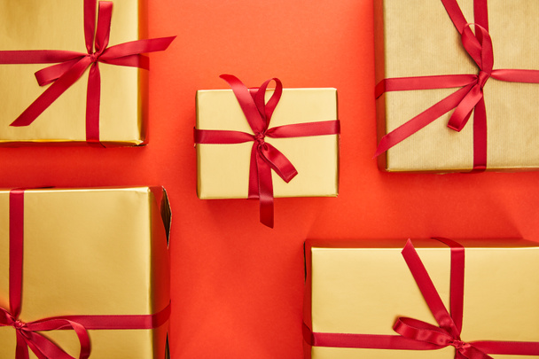 pose plate avec des boîtes-cadeaux dorées sur fond rouge
 - Photo, image