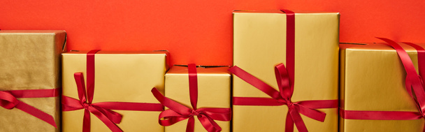 плоский лежал с золотыми подарочными коробками на красном фоне, панорамный снимок
 - Фото, изображение
