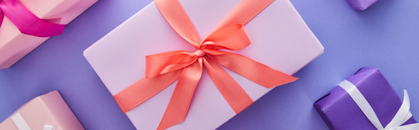 plano con coloridos regalos con arcos sobre fondo púrpura, plano panorámico
 - Foto, imagen