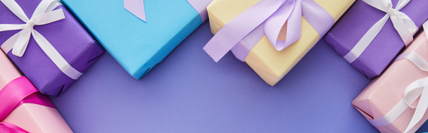 Draufsicht auf bunte Geschenke mit Schleifen auf lila Hintergrund mit Kopierraum, Panoramaaufnahme - Foto, Bild