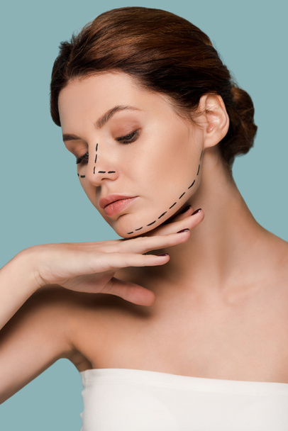 young woman touching face with marked lines isolated on blue  - Photo, Image