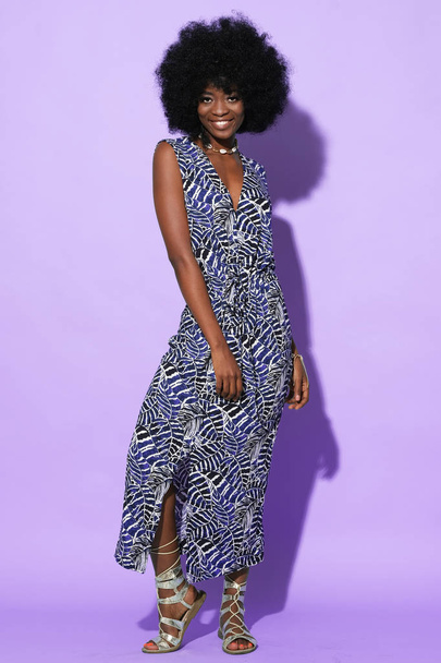 Full body foto van vrij afro-Amerikaans model in etnische lange jurk geïsoleerd op kleurrijke achtergrond. - Foto, afbeelding