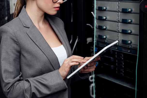 cropped view of businesswoman using digital tablet near server rack  - Foto, Imagen