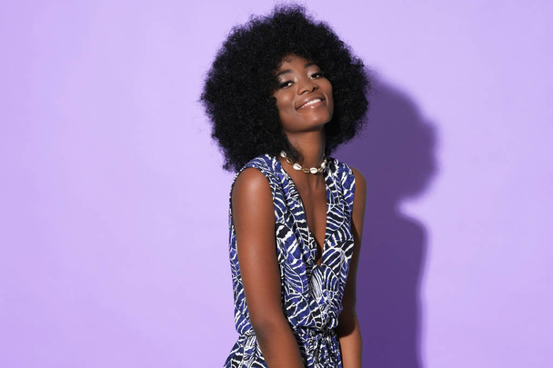 Vrij afro-Amerikaans model in etnische kleding geïsoleerd op kleurrijke achtergrond. - Foto, afbeelding