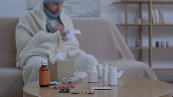 hombre grueso sentado cerca de la mesa con medicamentos e instrucciones de lectura
 - Imágenes, Vídeo