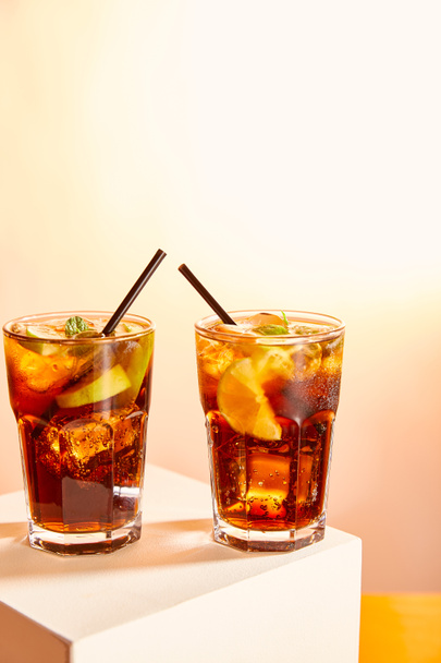 Cocktails cuba libre in Gläsern mit Strohhalmen auf Würfel   - Foto, Bild