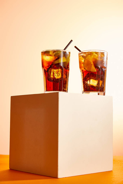 vue à angle bas de cocktails cuba libre dans des verres avec des pailles sur cube
   - Photo, image