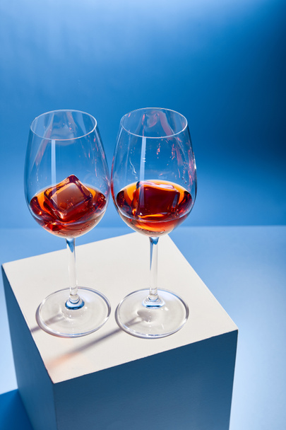 vue grand angle des cocktails Aperol Spritz avec glaçons dans des verres sur fond bleu
  - Photo, image