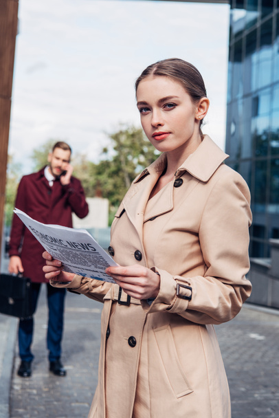 selective focus of attractive woman holding newspaper near man  - Foto, Imagen