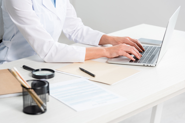 обрізаний вид дієтолога, що сидить за столом і використовує ноутбук у клініці
  - Фото, зображення