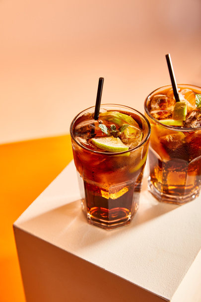 Hochwinkelaufnahme von Cocktails cuba libre in Gläsern mit Strohhalmen auf Würfel   - Foto, Bild