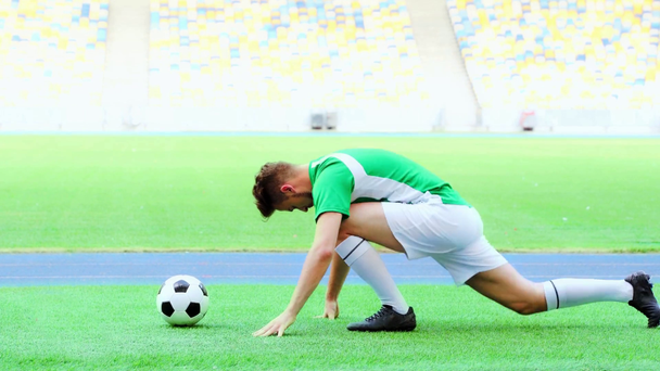 zijaanzicht van voetbal speler stretching benen  - Video