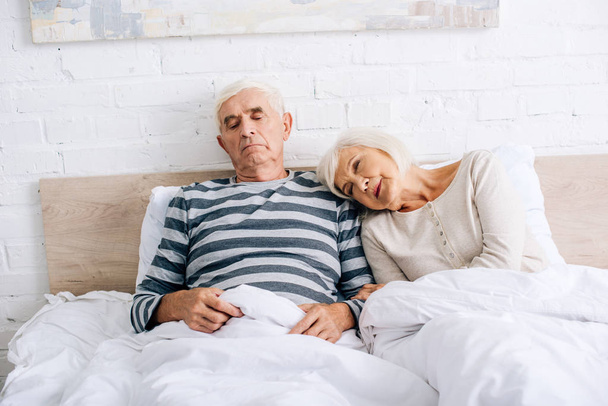 handsome husband and attractive wife lying in bed  - Fotó, kép
