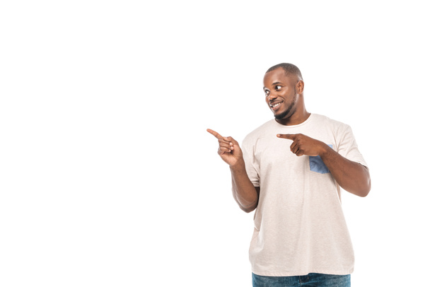 homem americano africano alegre olhando para longe e apontando com os dedos isolados no branco
 - Foto, Imagem