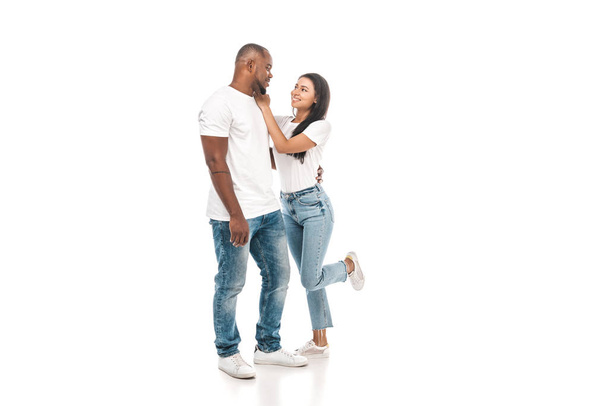cheerful african american woman touching face of handsome husband on white background - Foto, imagen