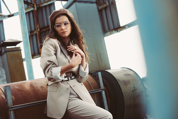 attractive fashionable model posing in beige suit and beret on urban roof - Photo, image