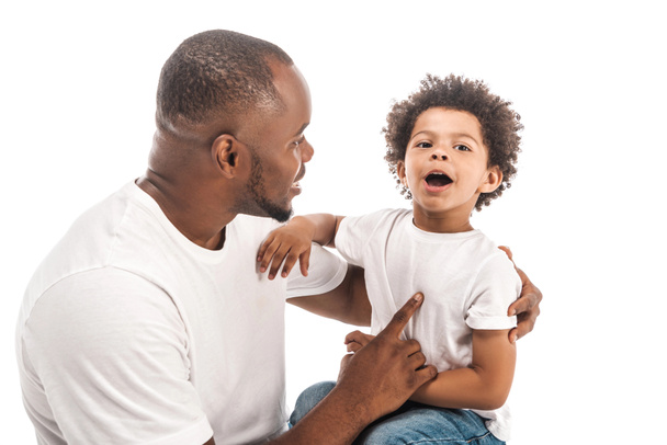 Yakışıklı Afrikalı Amerikalı adam beyaz arka planda sevimli oğluyla konuşuyor. - Fotoğraf, Görsel