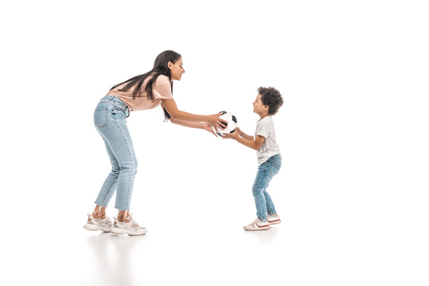 young african american woman giving soccer ball to adorable son on white background - Photo, Image