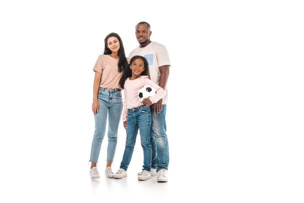 cute african american kid holding soccer ball while standing near parents on white background - Foto, imagen