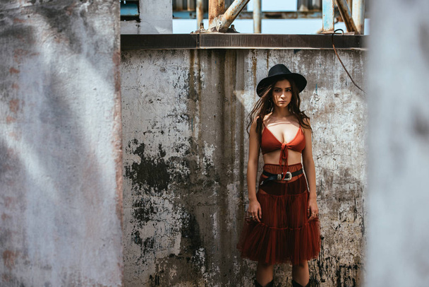 kaunis tyttö poseeraa punainen hame, rintaliivit ja hattu katolla
 - Valokuva, kuva