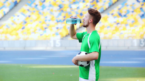 Futbolcu topu tutuyor, yürüyor ve su içiyor.  - Video, Çekim