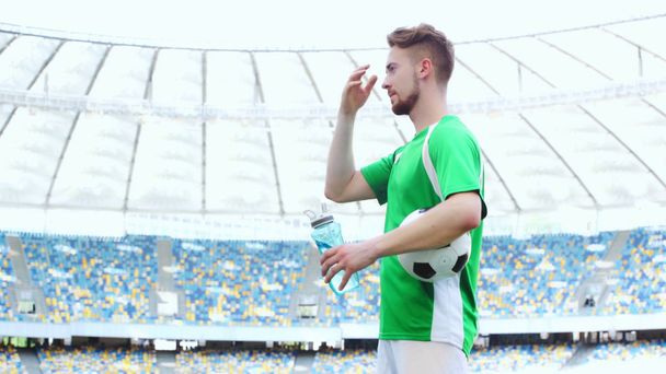 Fußballer halten Ball, gehen und trinken Wasser  - Filmmaterial, Video