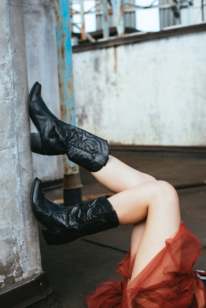 vista recortada de chica en botas de vaquero en el techo urbano
  - Foto, Imagen