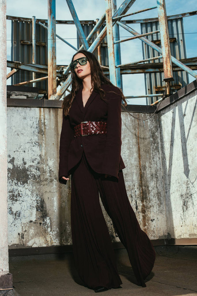 beautiful model posing in trendy burgundy suit on urban roof - Fotó, kép