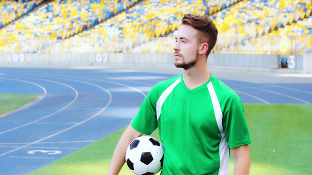 jugador de fútbol sosteniendo la pelota y mirando hacia otro lado
  - Metraje, vídeo