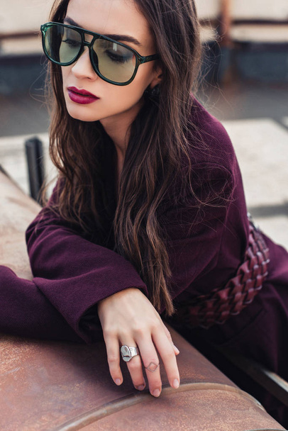 attractive elegant girl posing in trendy burgundy suit and sunglasses on urban roof  - Фото, изображение