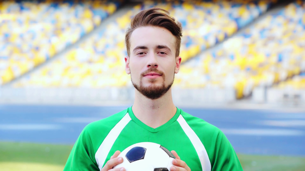 uśmiechnięty piłkarz trzyma piłkę  - Materiał filmowy, wideo