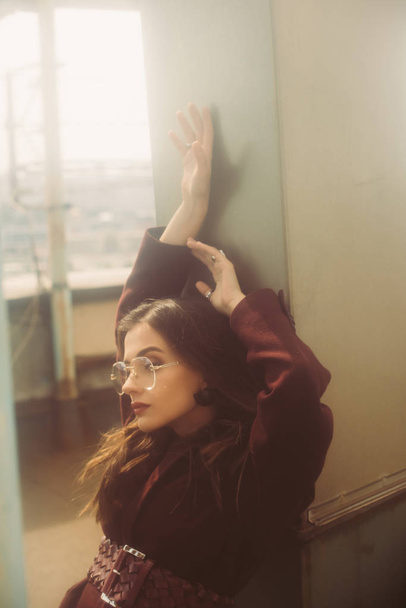 stylish girl posing in trendy burgundy suit and sunglasses on urban roof  - Foto, afbeelding