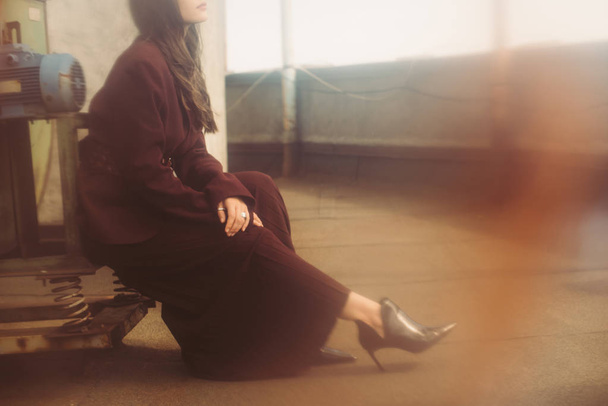 vista cortada de mulher elegante posando em terno borgonha na moda no telhado urbano
  - Foto, Imagem